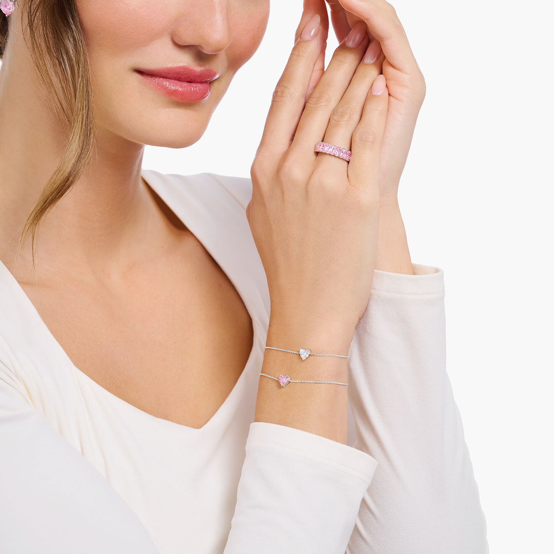 Woman wearing a bracelet and ring with pink gemstones on a white background